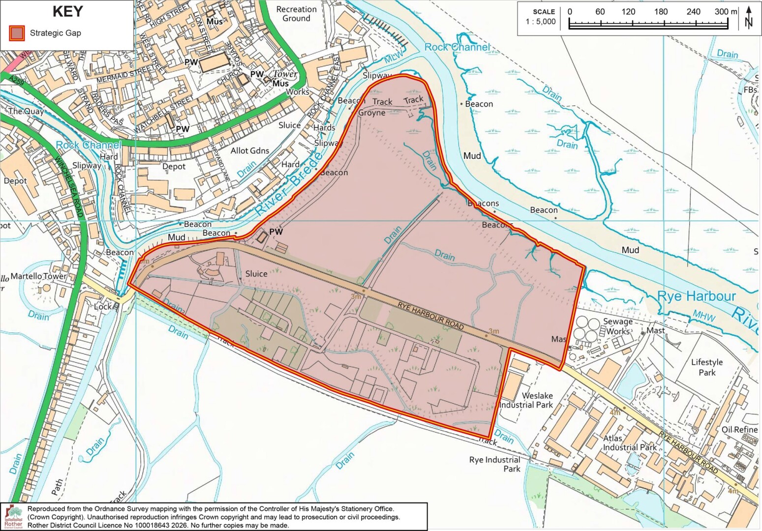 Strategic-gap map showing a large outlined redevelopment area around Rye Harbour, East Sussex, with industrial land, rail tracks, waterways, mudflats, and nearby residential areas. Red boundary and pink shading mark designated area, while green routes, blue drainage channels, labels, key, and 300-meter scale provide geographic context.
