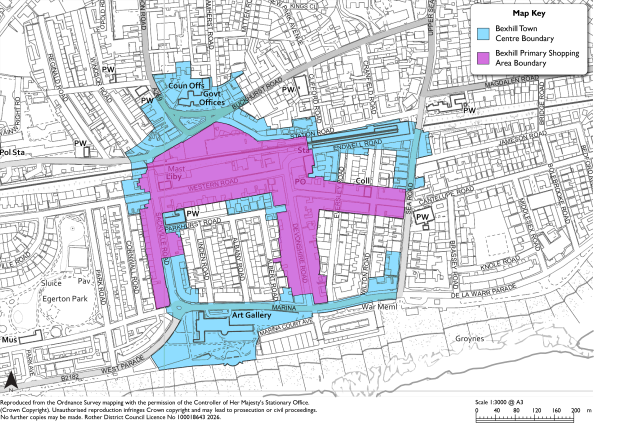 Planning map showing Bexhill Town Centre boundary and Bexhill Primary Shopping Area boundary for urban planning and retail-area definition. Cyan shading marks town-centre limits, magenta shading marks primary shopping area, with streets, buildings, landmarks, map key, scale bar, and north arrow labeled.