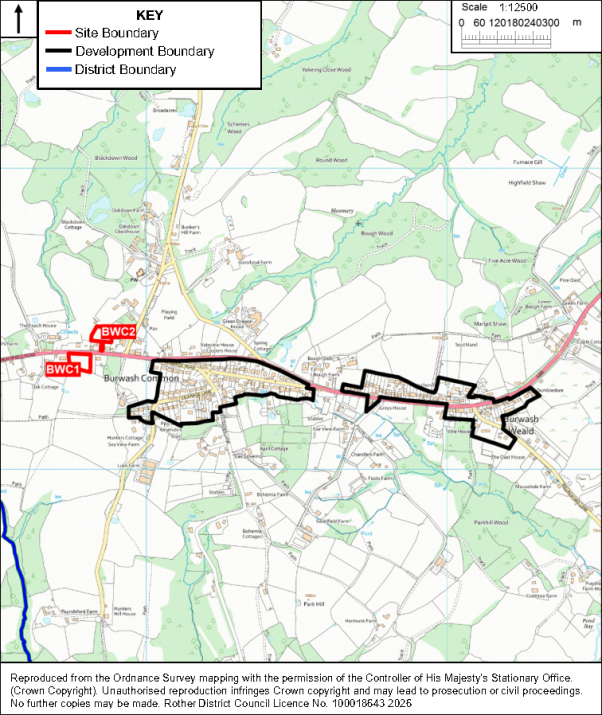 Planning map showing proposed development area and site boundaries around Burwash Common and nearby settlements. Black outline marks development boundary, red lines mark site boundaries labeled BWC1 and BWC2, blue line marks district boundary, with roads, waterways, woodland, and 1:12,500 scale bar.

